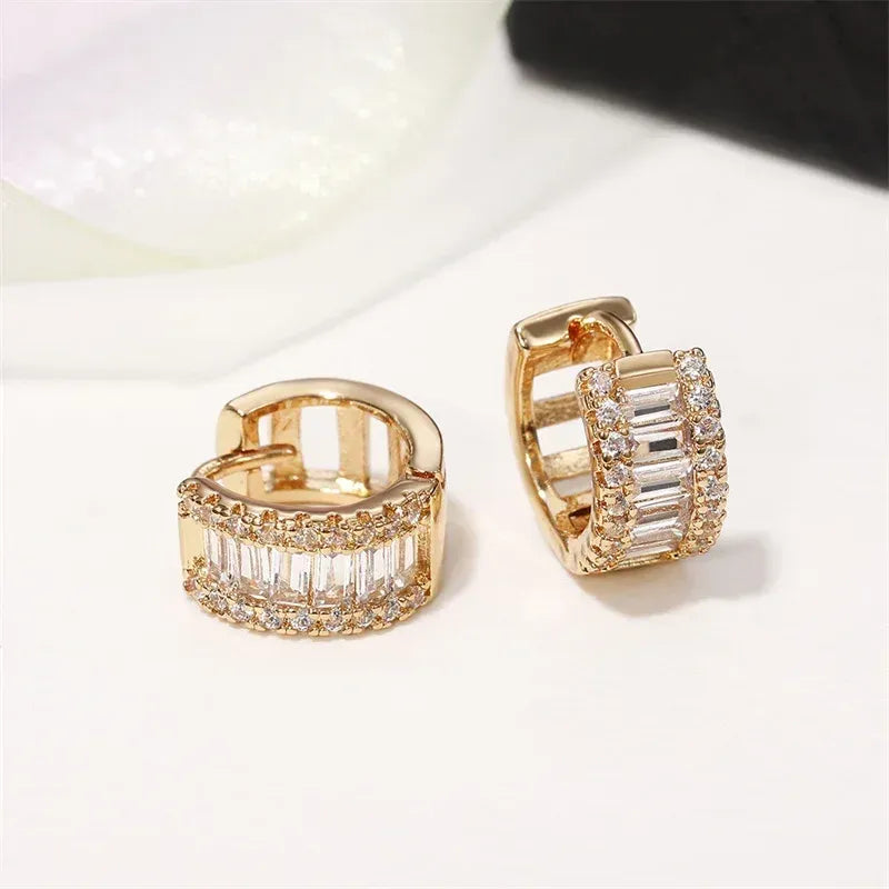 Brinco argola dourado com zircônias cravejadas, brilho intenso e acabamento sofisticado.