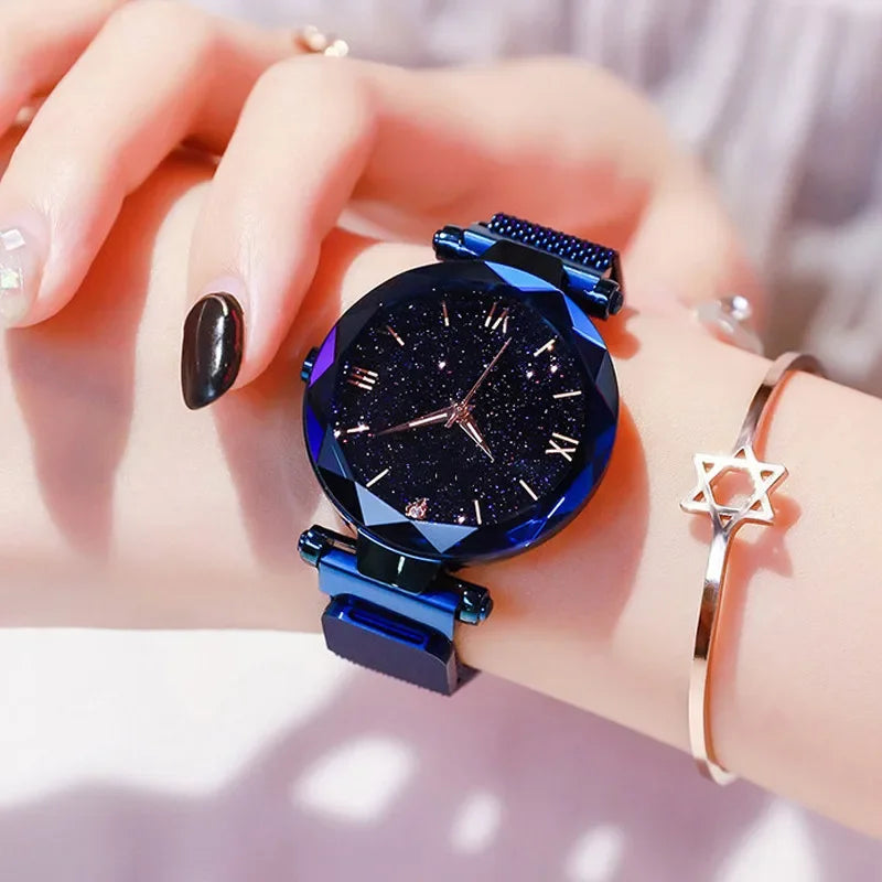 Relógio feminino azul com mostrador céu estrelado e pulseira moderna.