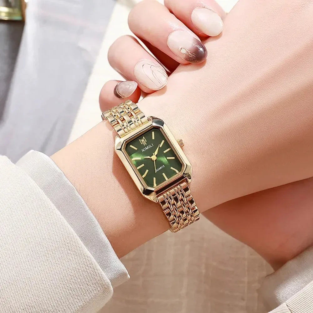Relógio feminino verde dourado com pulseira elegante no pulso