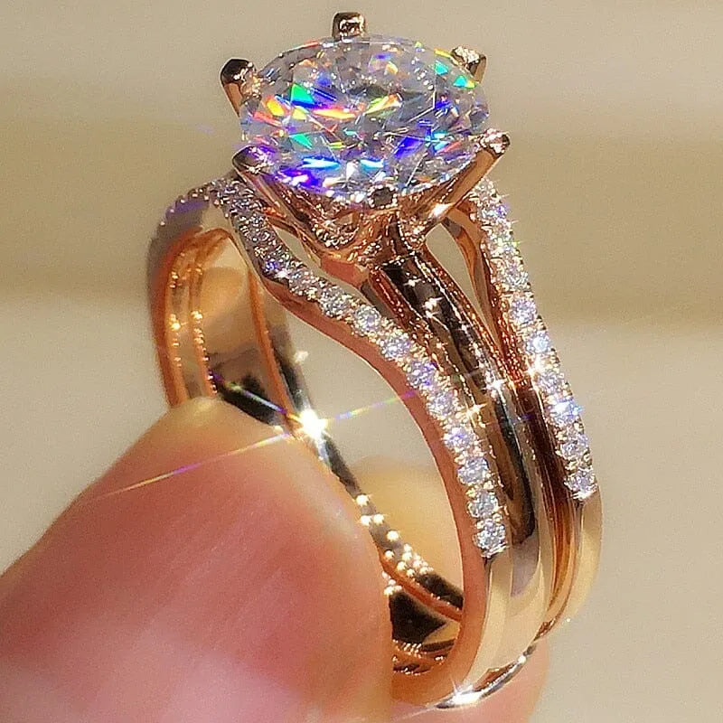 Anel solitário ouro rose com pedra zircônia brilhante e aro duplo cravejado, design elegante e sofisticado.