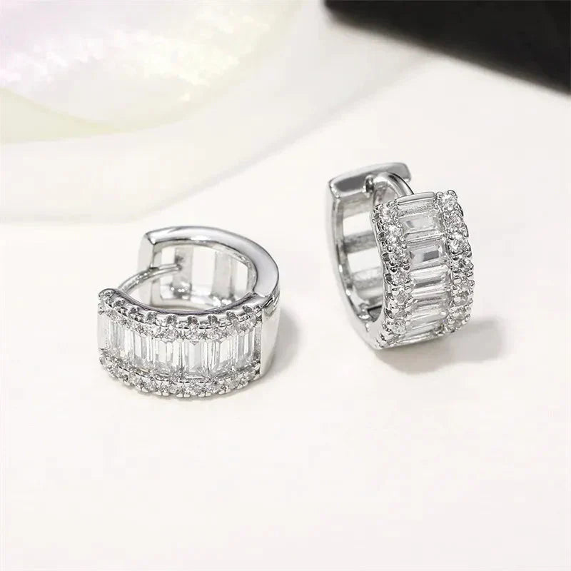 Brinco argola prata com zircônias cravejadas, design sofisticado e brilho intenso.