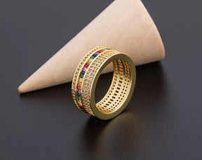 Anel dourado feminino com zircônias coloridas e detalhes cravejados, design delicado e elegante.