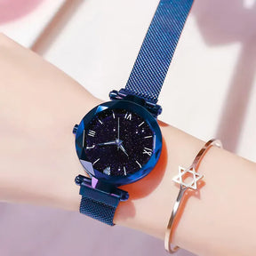 Relógio feminino azul com mostrador céu estrelado e pulseira moderna.