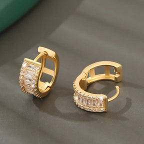 Brinco argola dourado com zircônias cravejadas, brilho intenso e acabamento sofisticado.