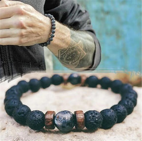 Pulseira masculina com pedras vulcânicas pretas e detalhes em madeira natural, estilo tibetano e rústico