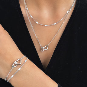 Conjunto com colar e pulseira em aço inox dourado ou prata com pingente de corações entrelaçados