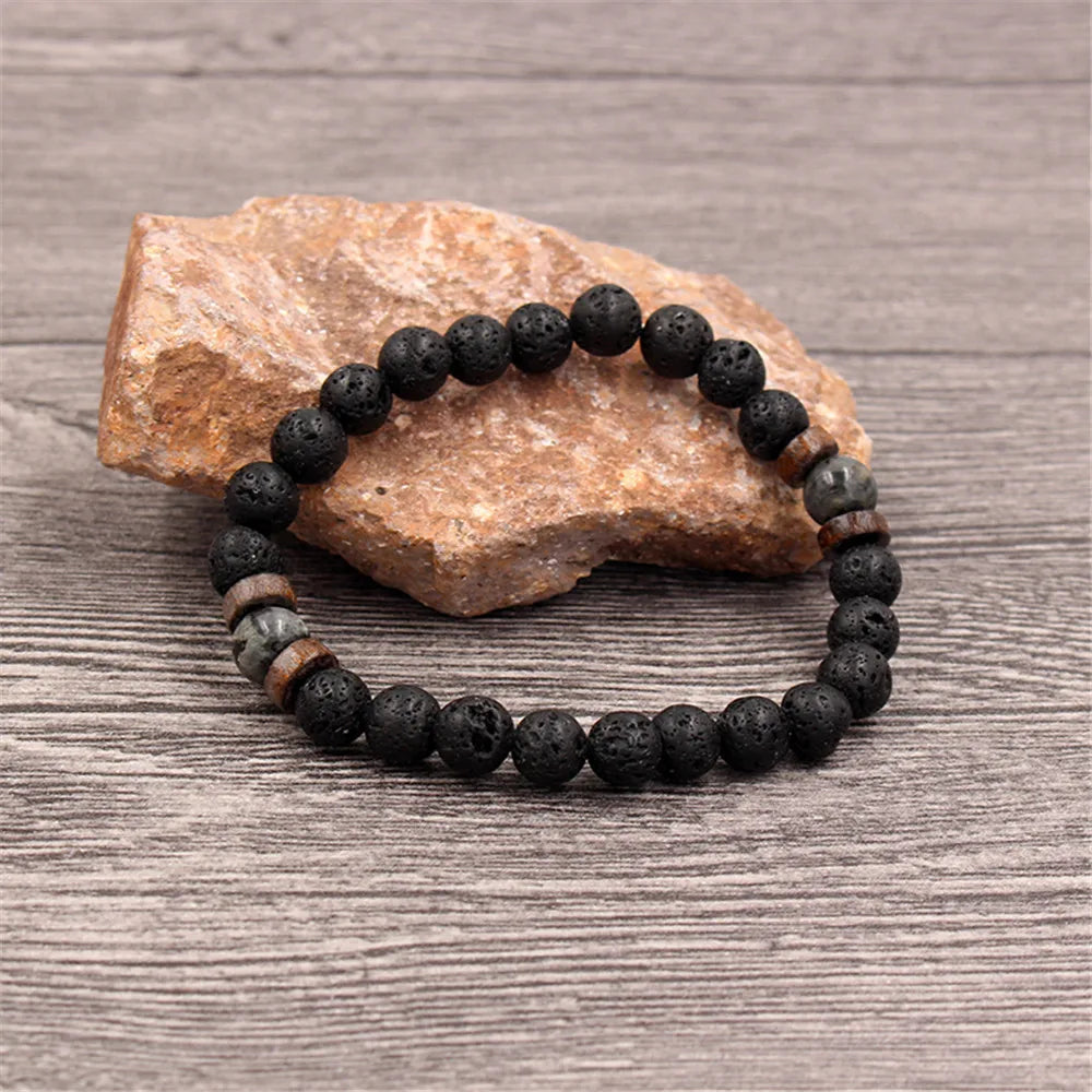 Pulseira masculina com pedras vulcânicas pretas e detalhes em madeira natural, estilo tibetano e rústico
