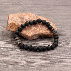 Pulseira masculina com pedras vulcânicas pretas e detalhes em madeira natural, estilo tibetano e rústico