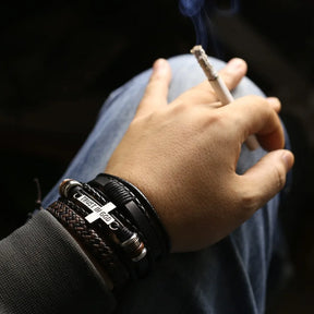 Pulseira com cruz “Trust in God” em couro trançado preto e marrom.

