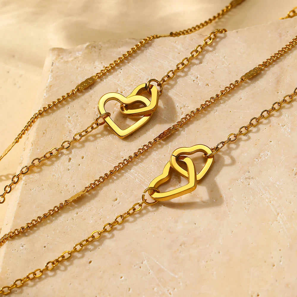 Conjunto com colar e pulseira em aço inox dourado ou prata com pingente de corações entrelaçados