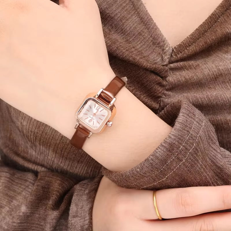 Relógio feminino Elegante com pulseira marrom de couro e mostrador quadrado dourado.