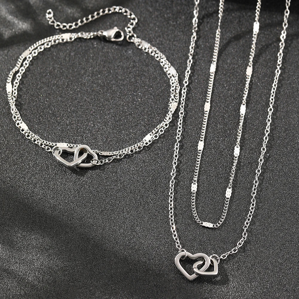 Conjunto com colar e pulseira em aço inox dourado ou prata com pingente de corações entrelaçados