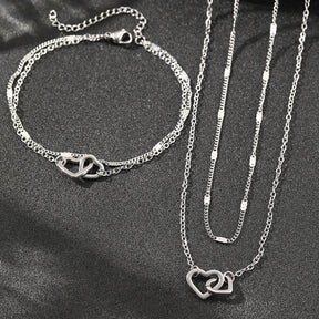 Conjunto com colar e pulseira em aço inox dourado ou prata com pingente de corações entrelaçados