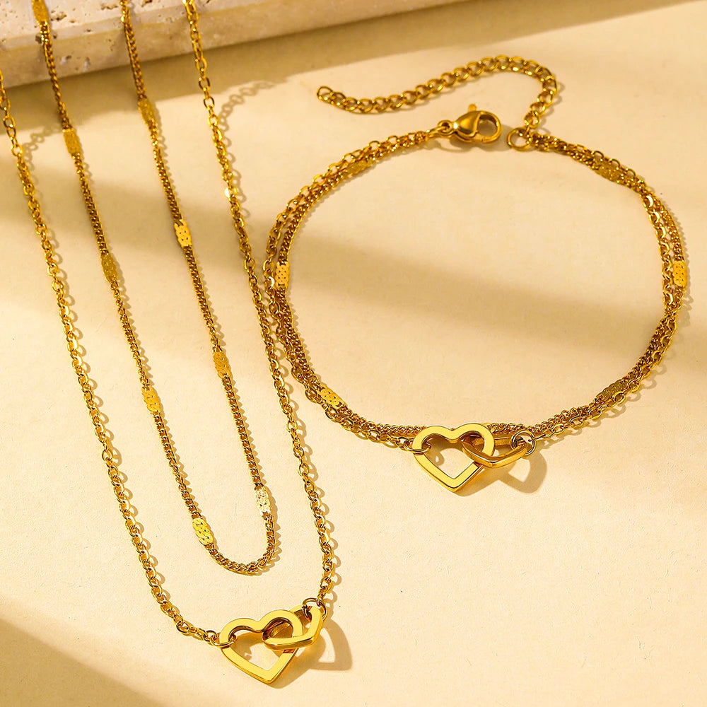 Conjunto com colar e pulseira em aço inox dourado ou prata com pingente de corações entrelaçados
