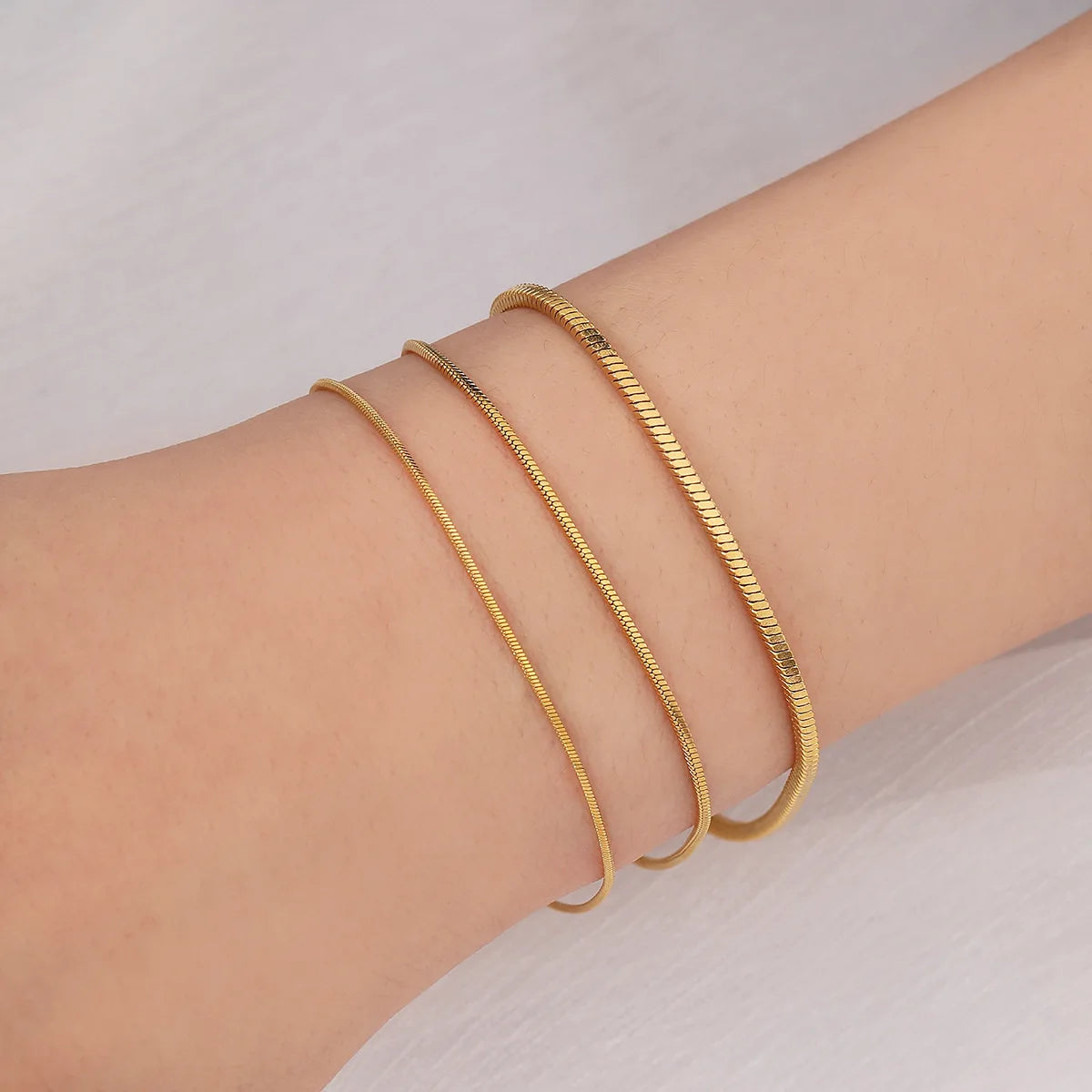 Pulseira dourada minimalista em aço inox com corrente snake bone