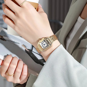 Relógio feminino dourado com mostrador romano e pulseira aço inox.
