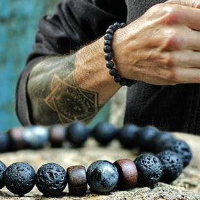 Pulseira masculina com pedras vulcânicas pretas e detalhes em madeira natural, estilo tibetano e rústico