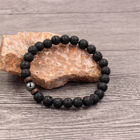 Pulseira masculina com pedras vulcânicas pretas e detalhes em madeira natural, estilo tibetano e rústico