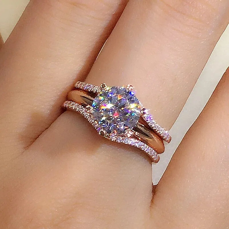 Anel solitário ouro rose com pedra zircônia brilhante e aro duplo cravejado, design elegante e sofisticado.